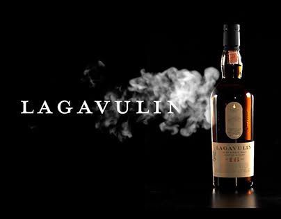 Lagavulin 16 bottle next to a glass of peated whisky