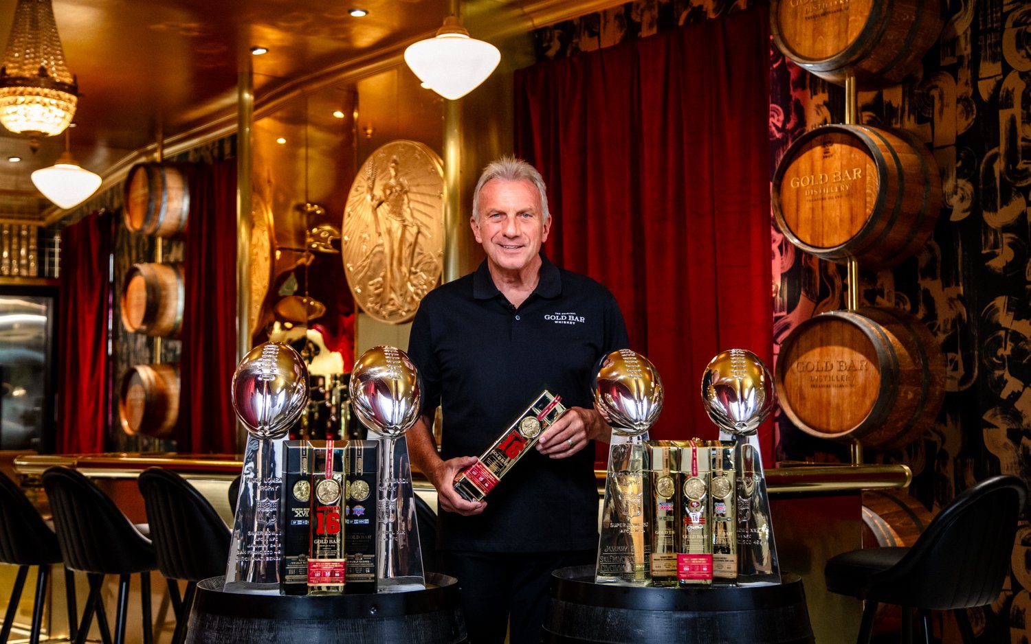 Joe Montana holding a bottle of Gold Bar Whiskey