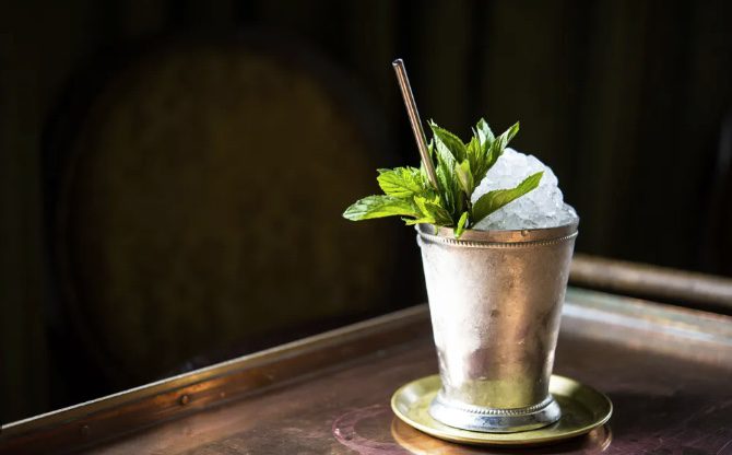 The perfect mint julep recipe in a silver cup with crushed ice