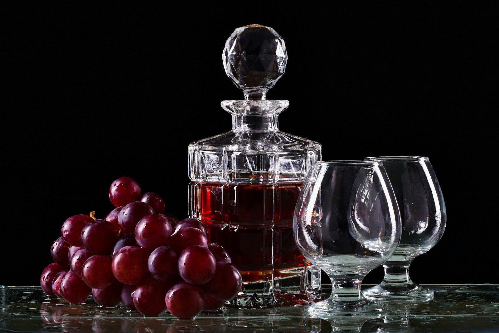 Whisky food pairing concept with red grapes and crystal decanter